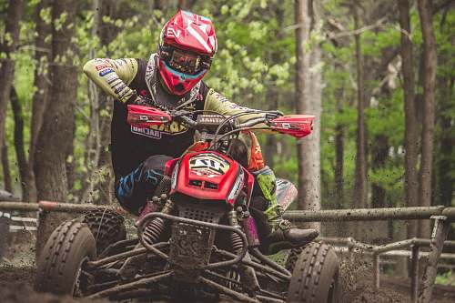 person man riding ATV outdoor near trees people