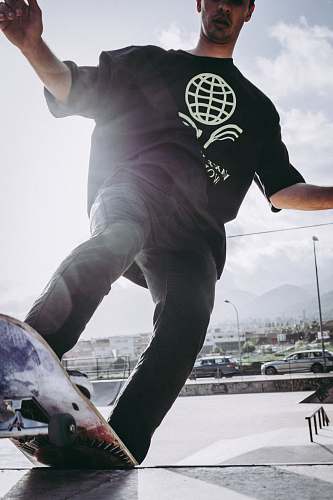 person man riding black and white skateboard apparel