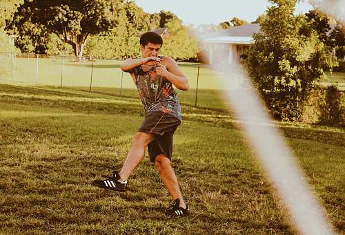 person man standing on green field apparel