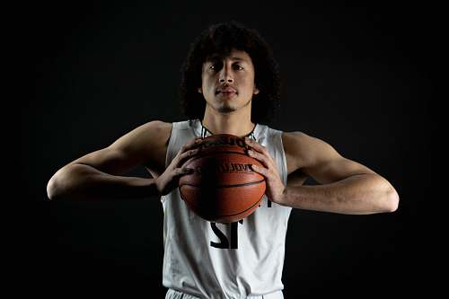 person man wearing white 12 jersey holding basketball with both hands people