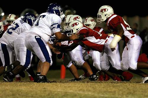 helmet men playing American football on green grass field football