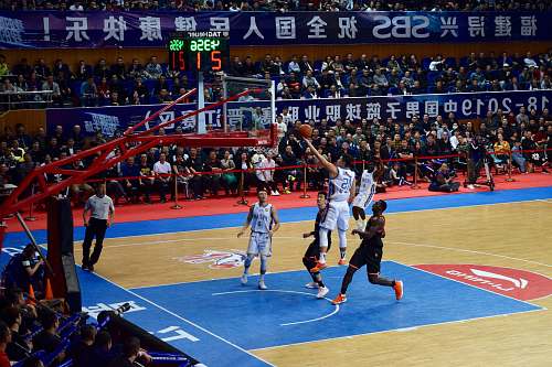 person men playing basketball game surrounded with people watching people