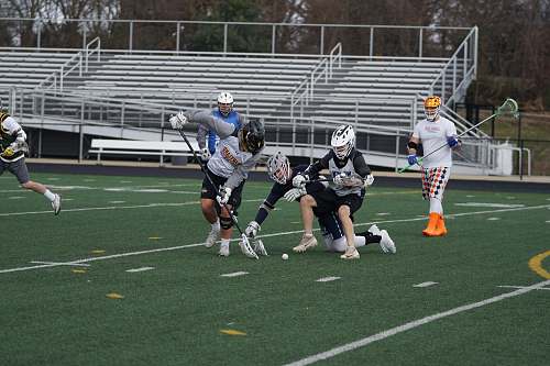 person men playing lacrosse in field apparel