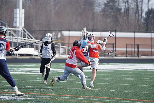 person men playing lacrosse sport during daytime apparel