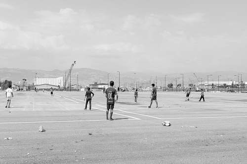 person men playing on field photo black-and-white