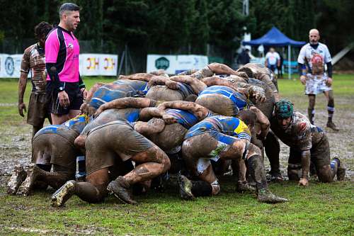 person men playing rugby on mud people