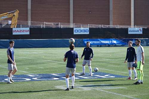 person men playing soccer during daytime people
