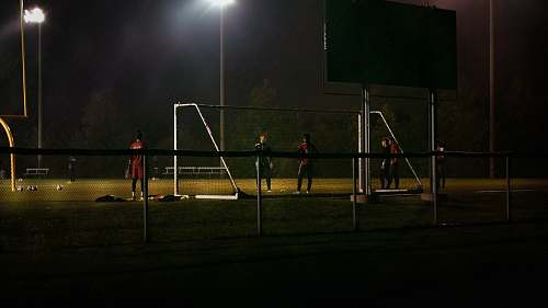 person men plays soccer during nighttime people
