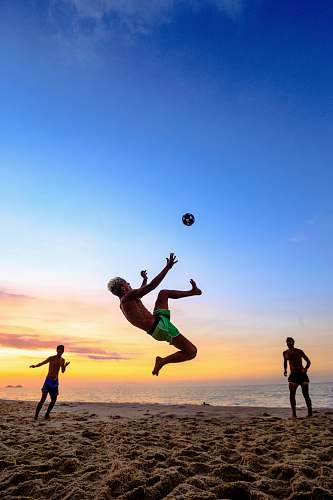person people playing at the beach during day shorts