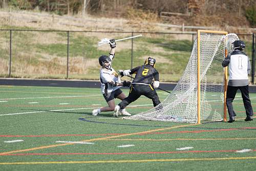 people people playing lacrosse during daytime person