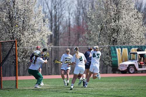 person people playing lacrosse on field during daytime people