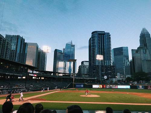 person people watching baseball game during daytime building