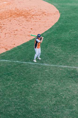 person person holding baseball bat on green field apparel