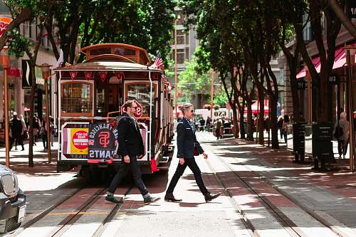 person person passing through road beside tram people