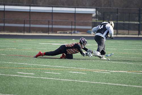 person person playing lacrosse on field apparel