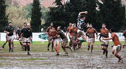 person person wearing black jersey jumps across people wearing orange jerseys people