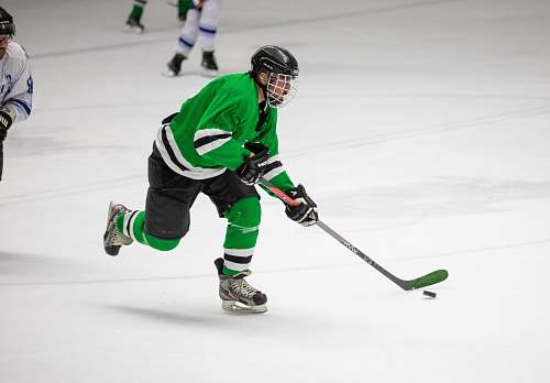 person photography of man in green jersey shirt playing hockey apparel
