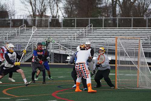 person players playing lacrosse game in field people