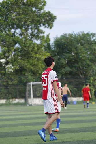 person selective-focus of man wearing white and red jersey shirt and bottoms apparel
