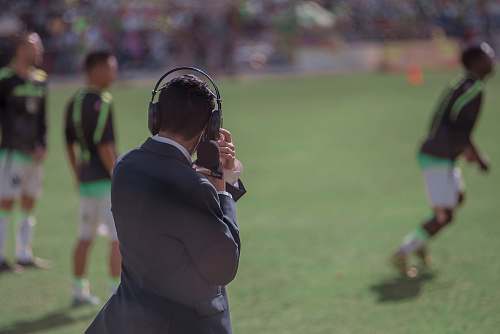 person selective focus photography of man using headphones near athletes people