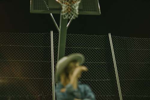 person selective focus photography of woman wearing gray hat on basketball court people