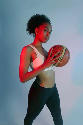 person standing woman wearing pink sports bra holding basketball hair