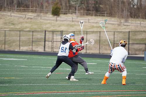 person three men holding lacrosse sticks apparel