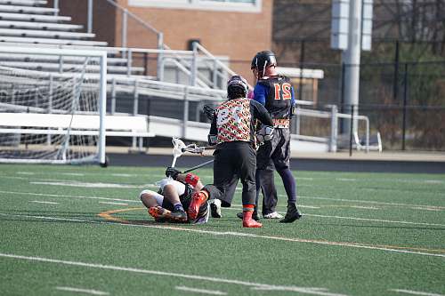 person three person playing lacrosse at field apparel