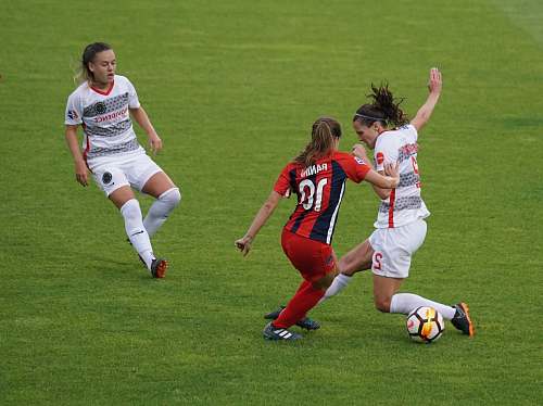person three women playing soccer people