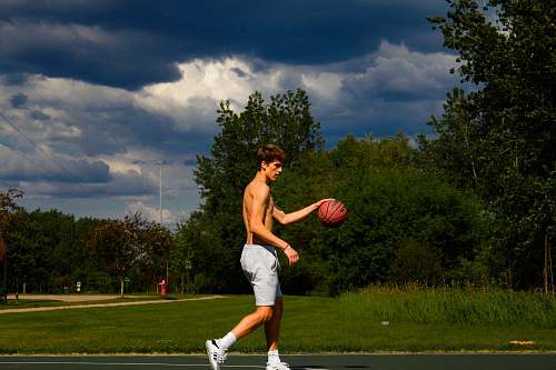 person topless man holding basketball during daytime people