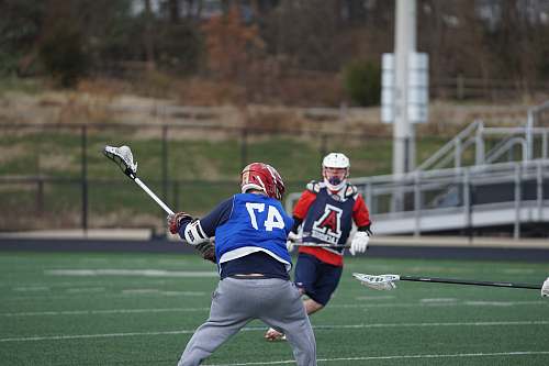 clothing two men playing lacrosse on field apparel