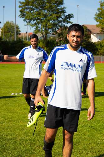 person two men standing in green field during daytime apparel