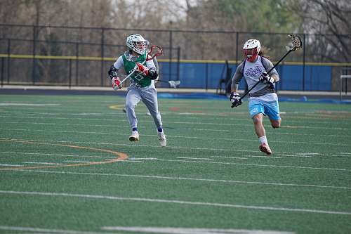 person two people playing lacrosse during daytime people
