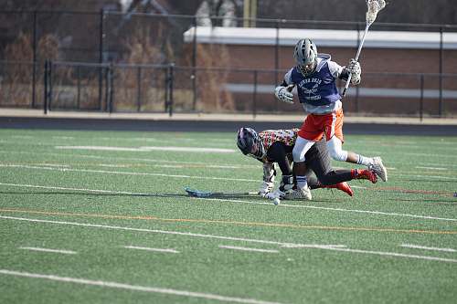 person two person playing lacrosse during daytime apparel