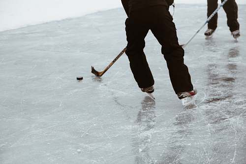 person two persons playing hockey on ice field sport