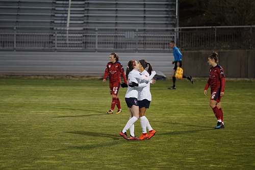 person two sports players hugging in field people