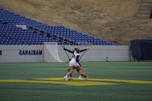 person two women holding lacrosse stick people