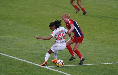 football two women playing soccer on field soccer