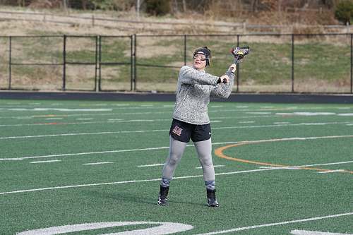 person woman in grey sweat shirt playing lacrosse during daytime people