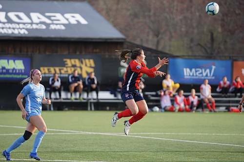 person woman jumping about to catch soccer ball people