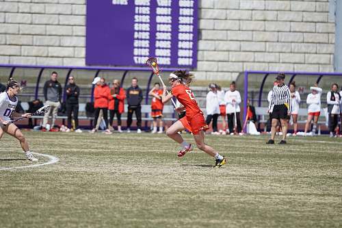 person woman playing lacrosse on the field people