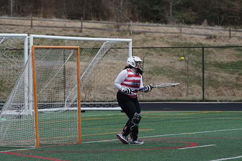 person woman standing on grass field beside goal net apparel