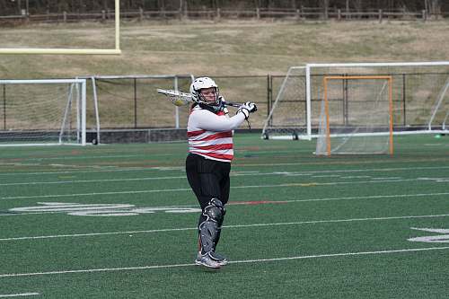 person woman standing on playing field holding cricket bat during daytime field