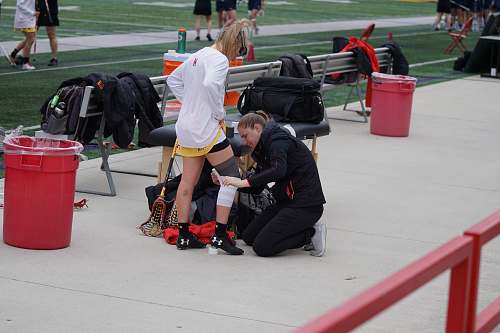 person woman taping knee of woman apparel