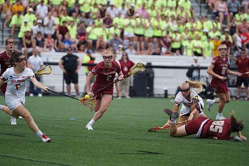 person woman wearing white and red jersey playing on field field