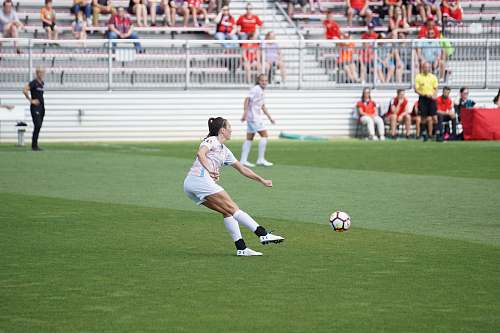 person women athletes playing soccer during daytime soccer