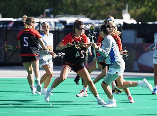 person women playing lacrosse during day time people