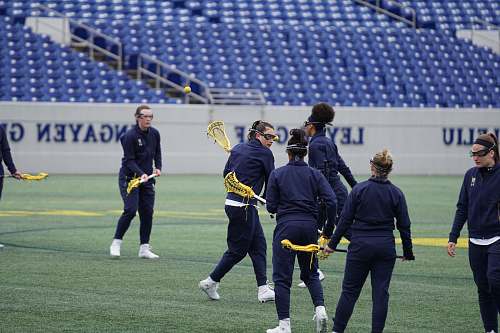 person women playing lacrosse on field during daytime apparel