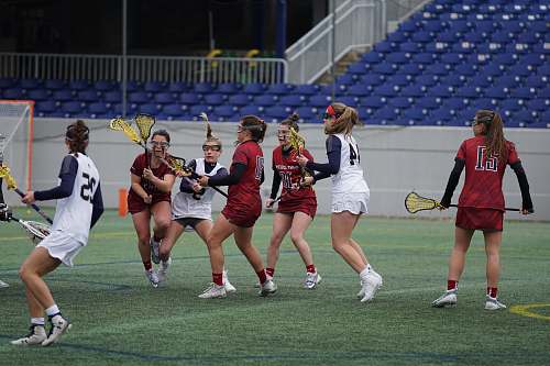 person women playing lacrosse on field racket