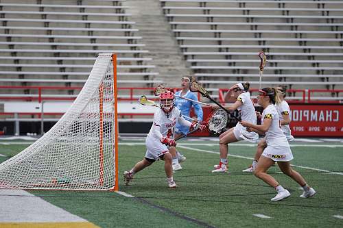 person women playing lacrosse outside during daytime people